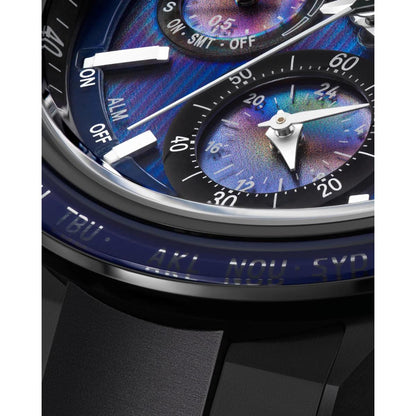 Close-up of a luxury watch with a colorful face and black strap.