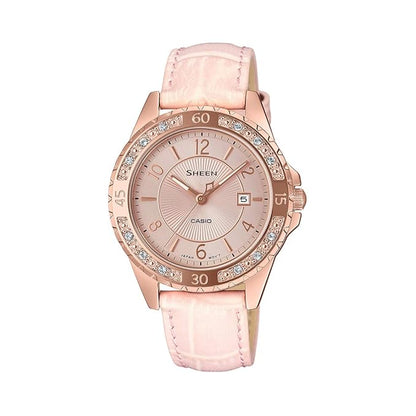 A Casio analog women's watch with a pink dial and a pink leather strap, featuring a diamond-like pattern around the bezel.