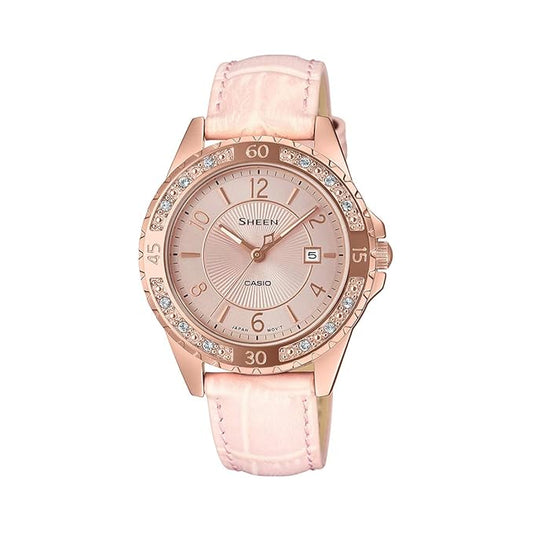 A Casio analog women's watch with a pink dial and a pink leather strap, featuring a diamond-like pattern around the bezel.