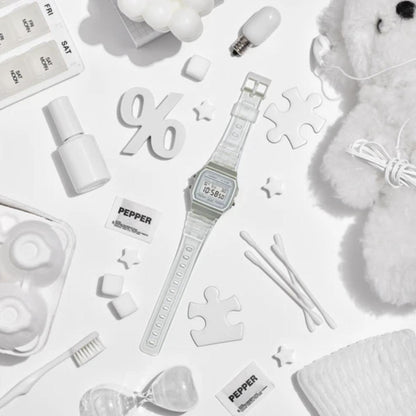 White digital watch surrounded by various items on a white background