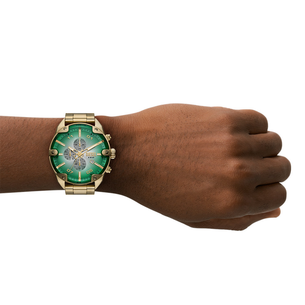 Gold watch with a green face on a wrist against a white background
