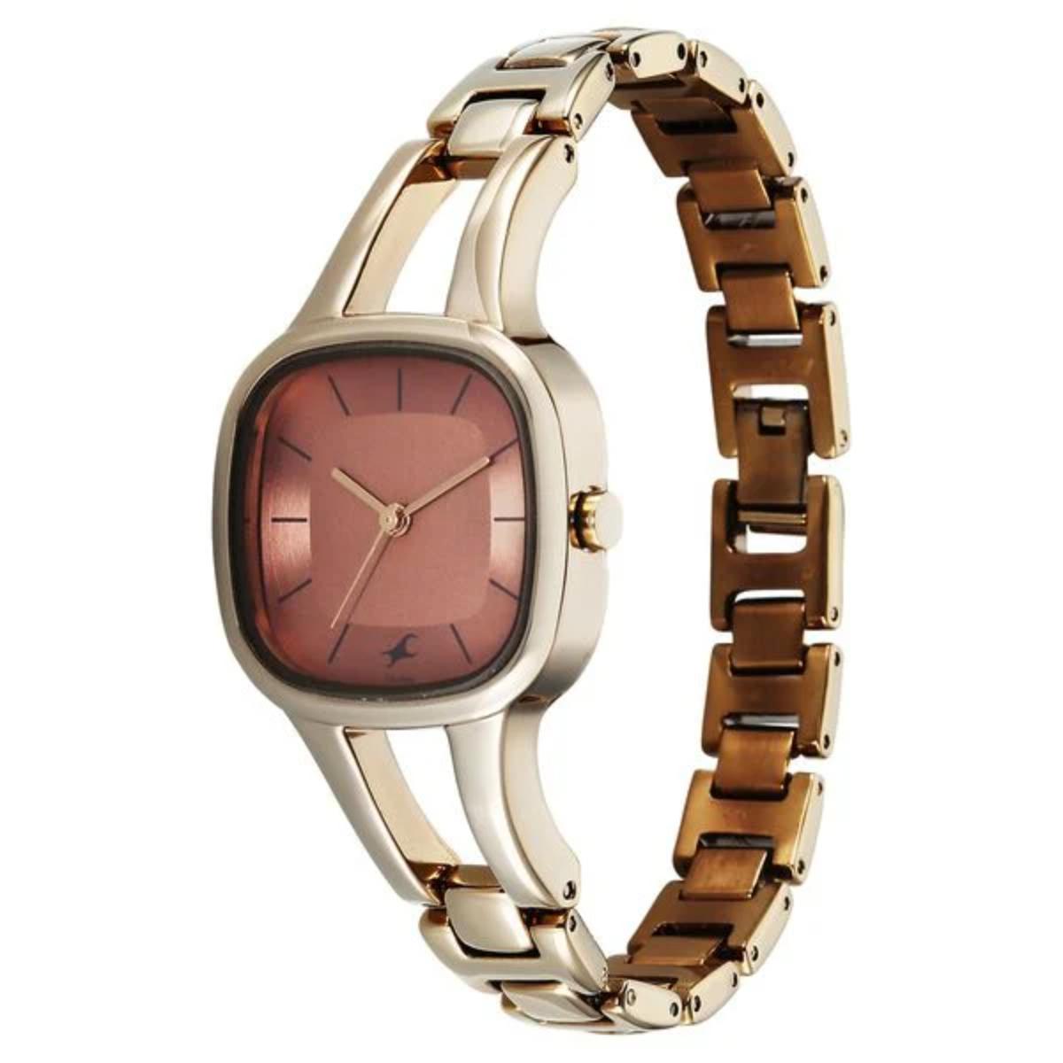 Gold and rose gold watch with a pink face on a white background