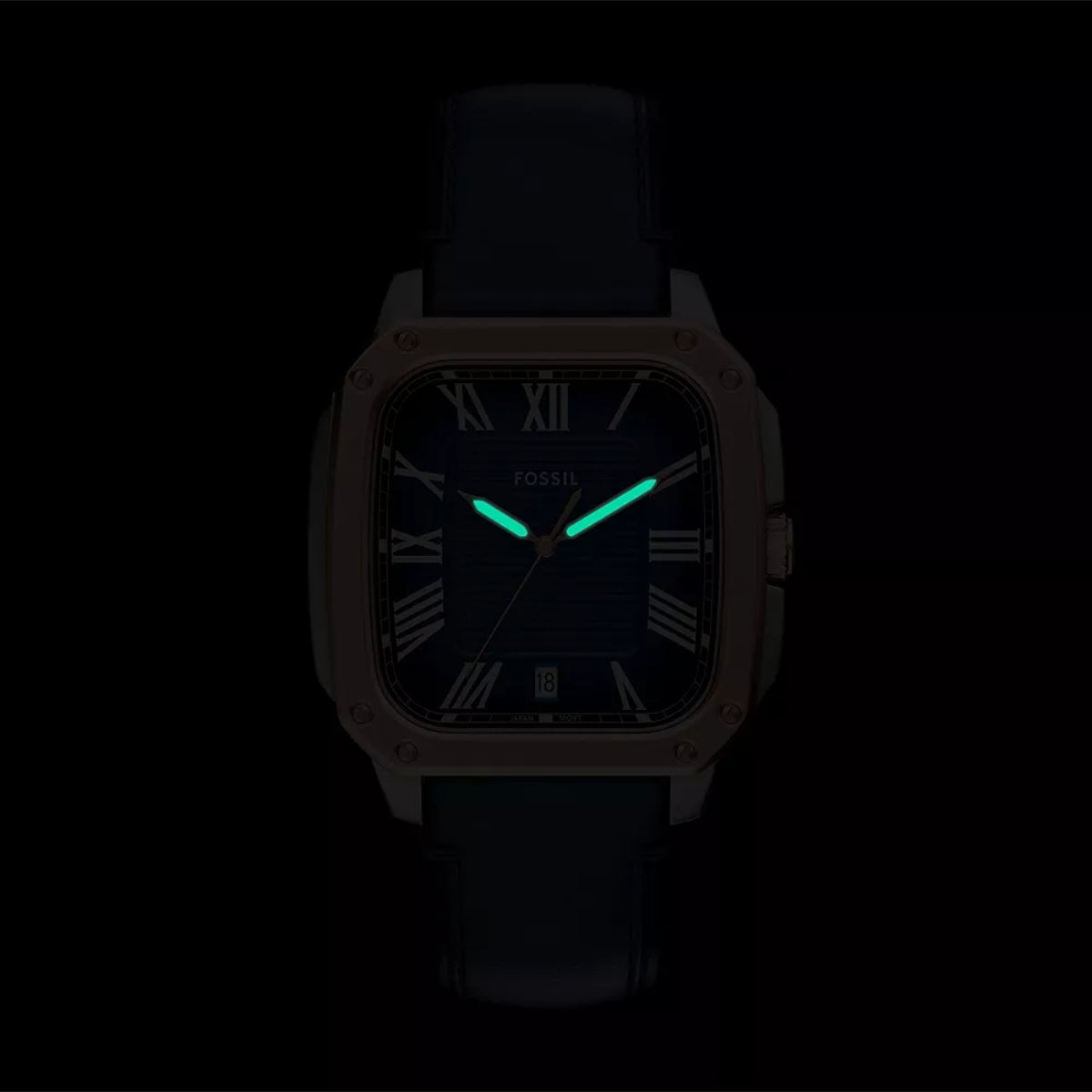 Fossil watch with glowing green hands on a black background