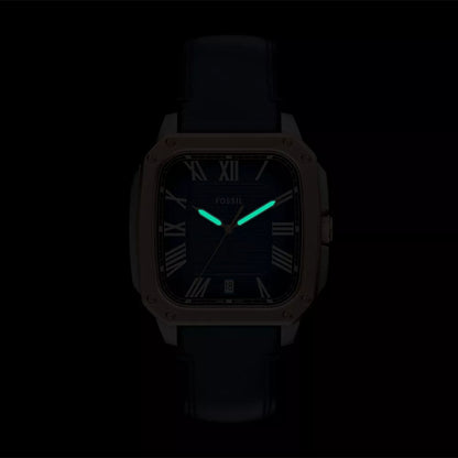 Fossil watch with glowing green hands on a black background