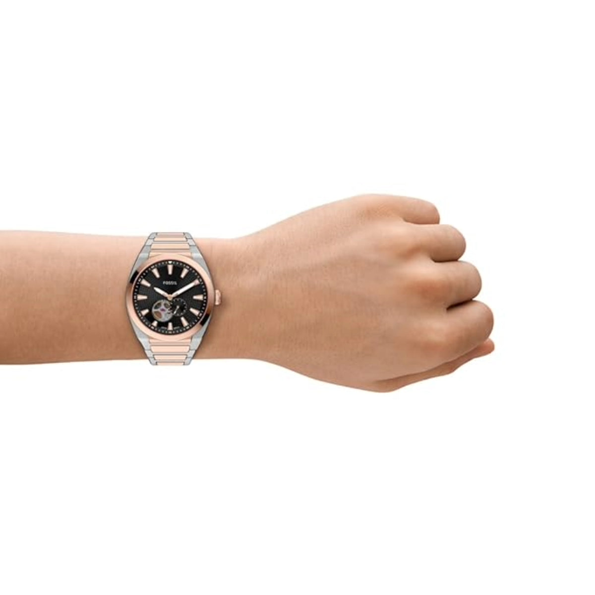 Hand wearing a rose gold watch with a black face on a white background
