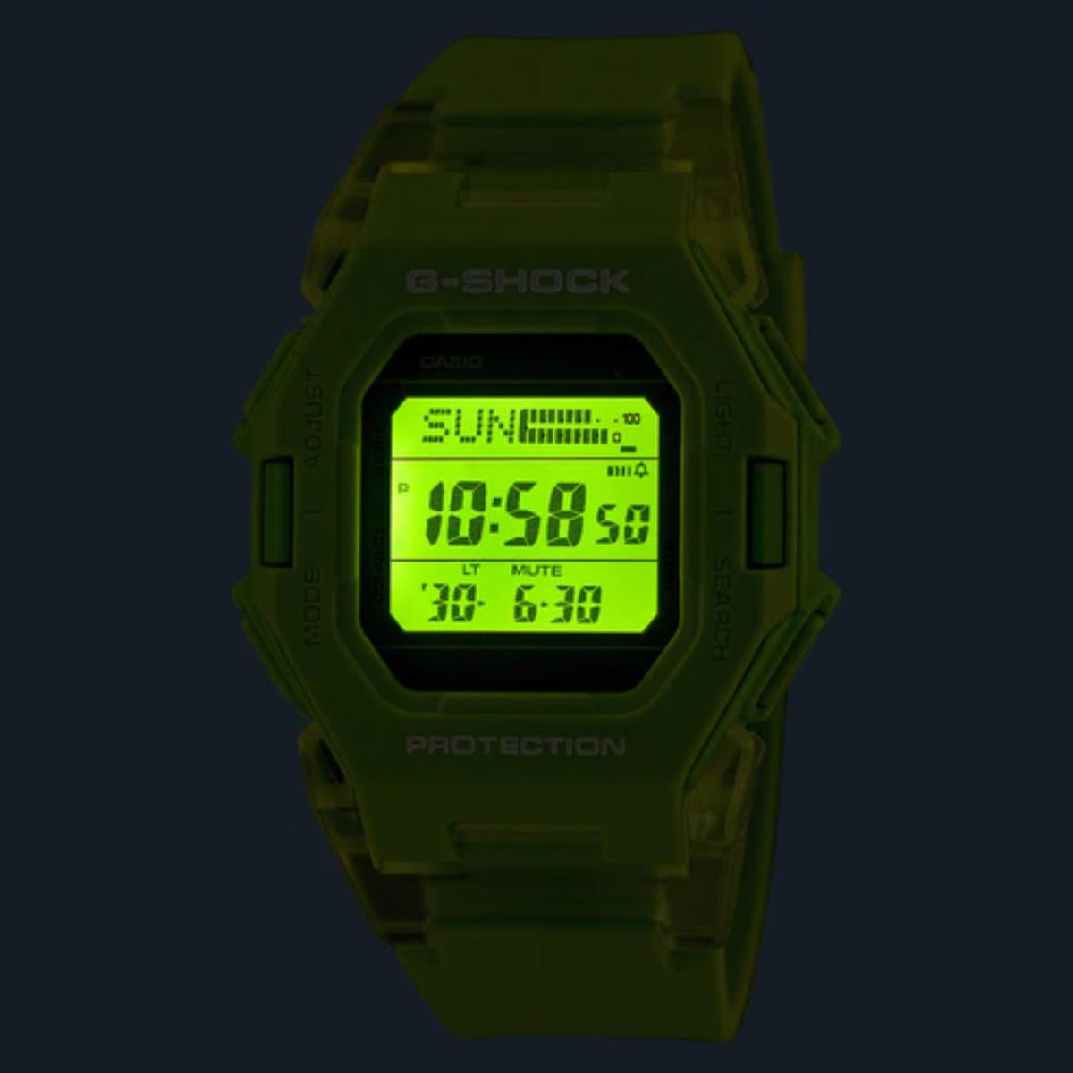Green digital watch with 'G-Shock' branding on a dark background