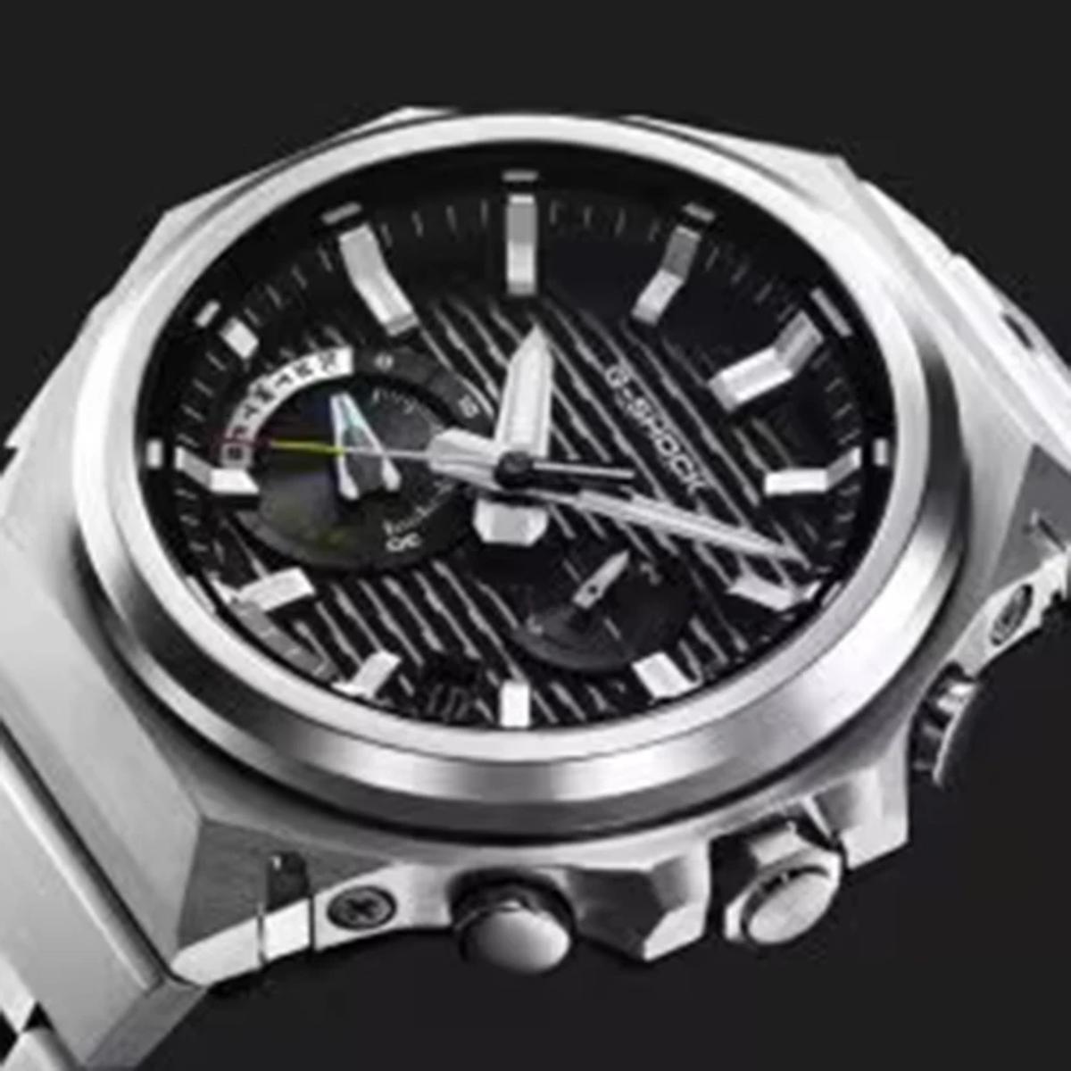 Silver watch with a black face on a black background