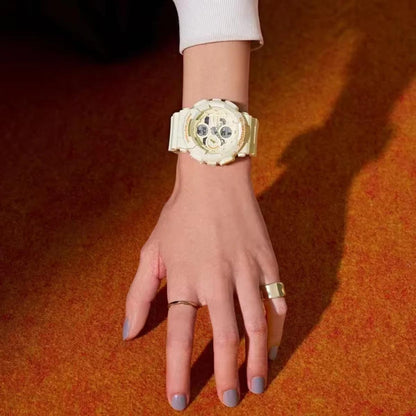 Gold watch on a wrist with a plain background