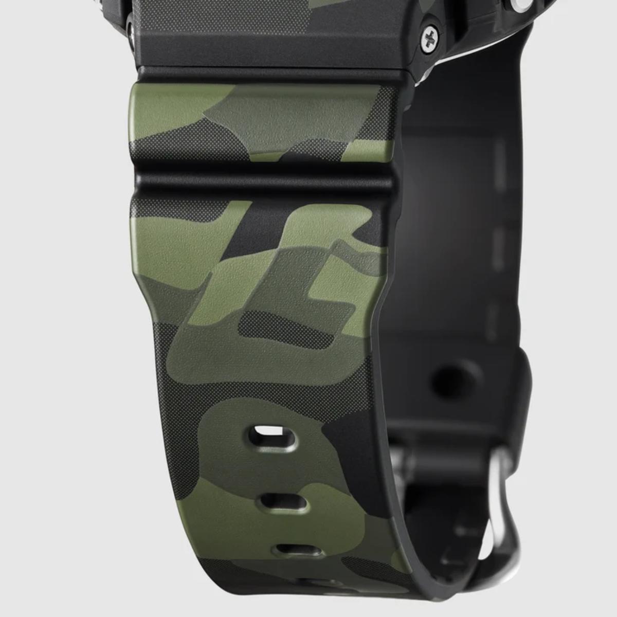 Close-up of a watch with a green camouflage band on a light gray background