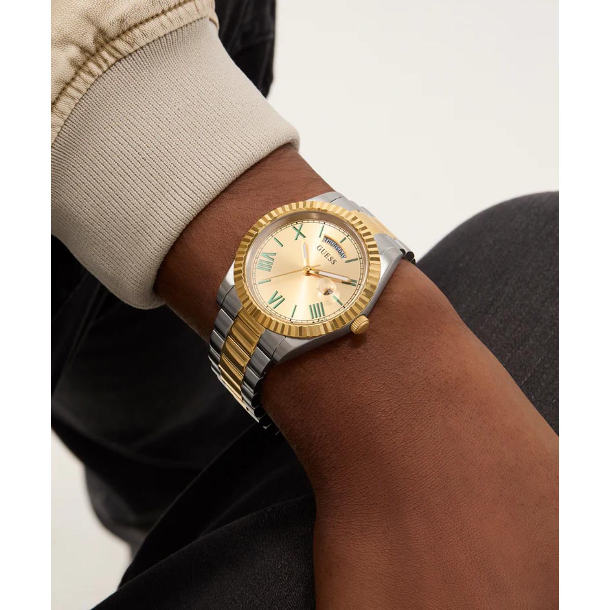 Gold and silver watch on a wrist with a neutral background