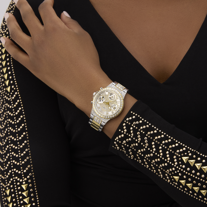 Gold wristwatch on a hand with black and gold studded sleeve