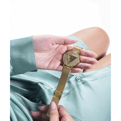 Gold watch with a unique design held by a person wearing a light blue shirt.