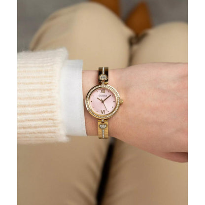 Gold watch on a wrist with a neutral background