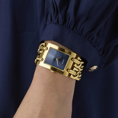 Gold chain-link watch on a wrist with a blue face against a navy background