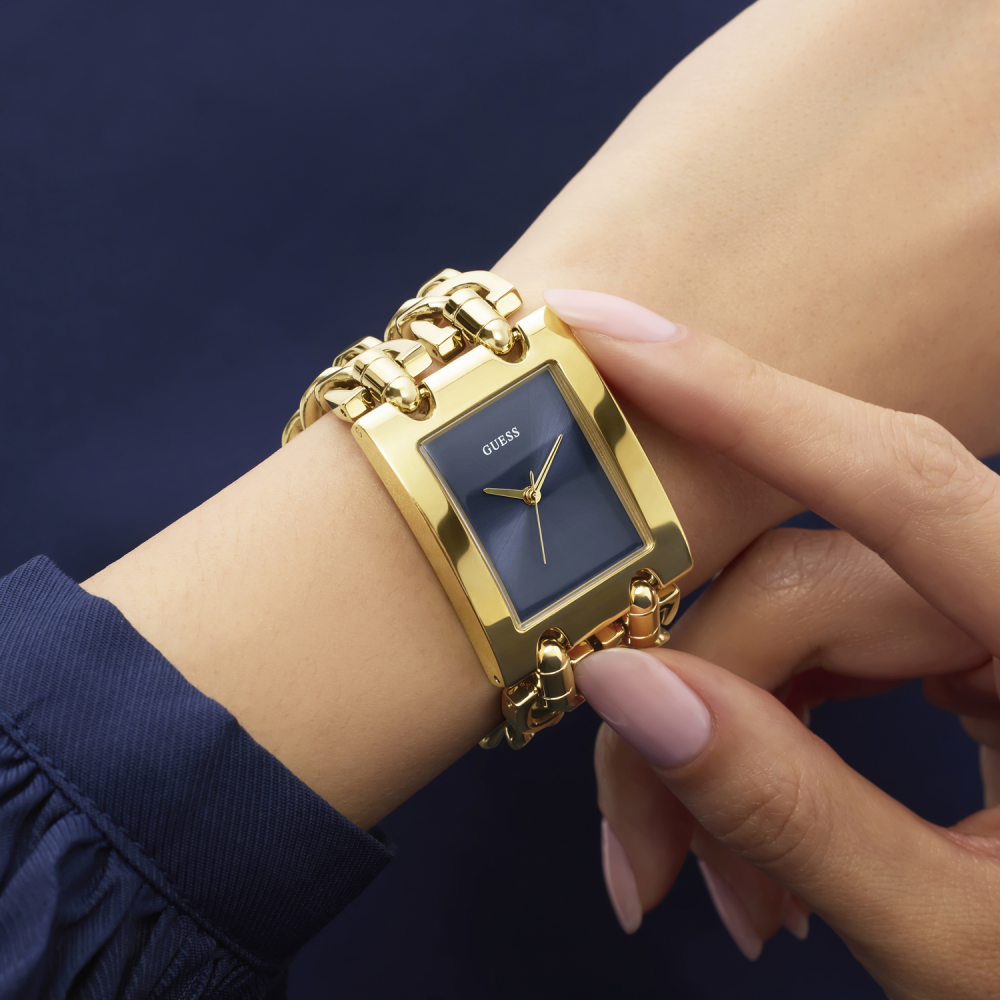 Gold watch with a blue face on a wrist against a dark background