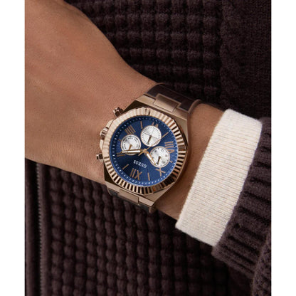 Luxury watch with a blue face and rose gold case on a wrist.