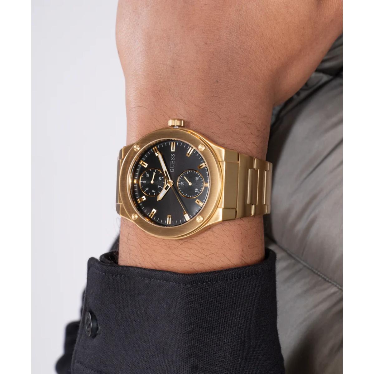 Gold wristwatch on a person's wrist with a plain background