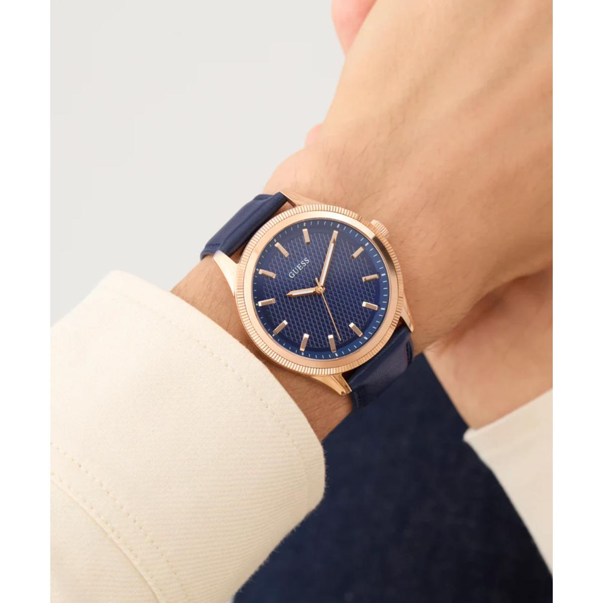 Wrist wearing a watch with a blue strap and rose gold case on a neutral background