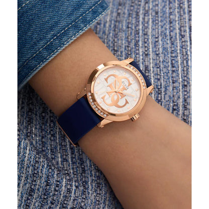 Wrist wearing a watch with a blue strap and rose gold case on a denim background