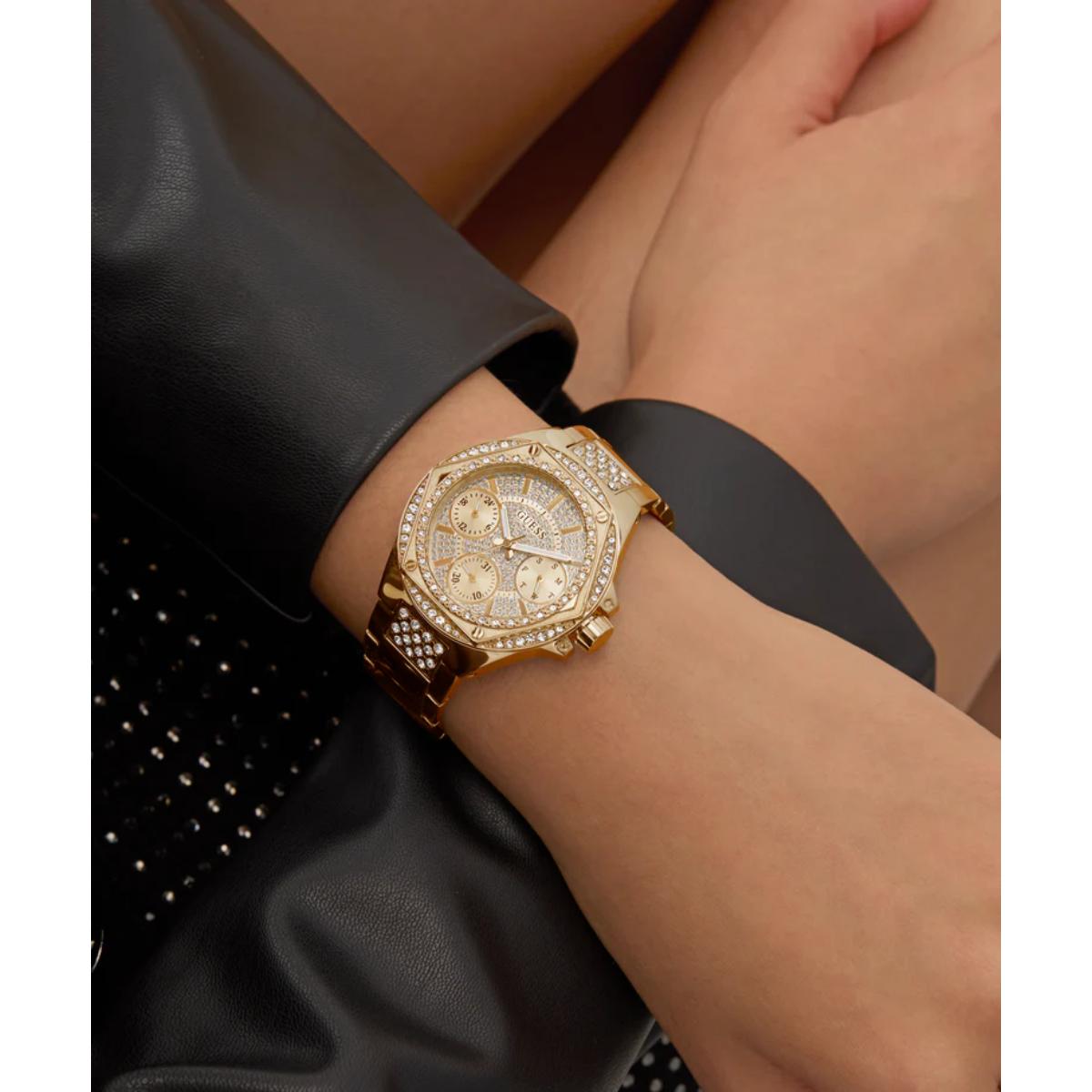 Gold wristwatch on a person's wrist with a black leather sleeve.