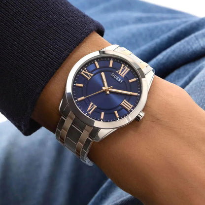 Silver watch with a blue face on a wrist, brand 'Guess' visible
