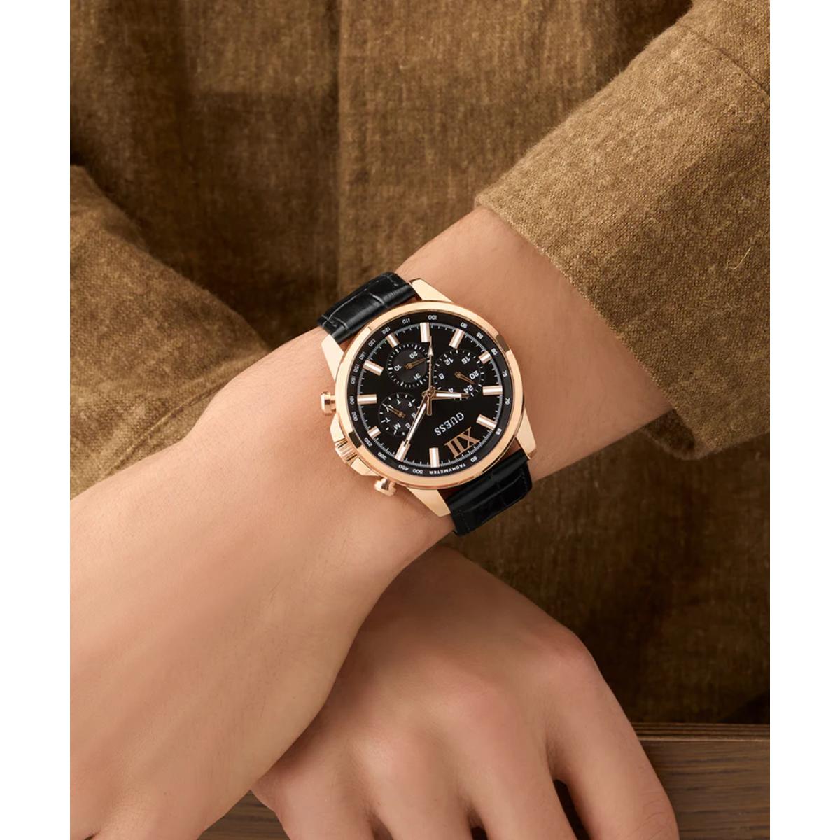 Luxury watch with black dial and gold case on a wrist, against a brown background
