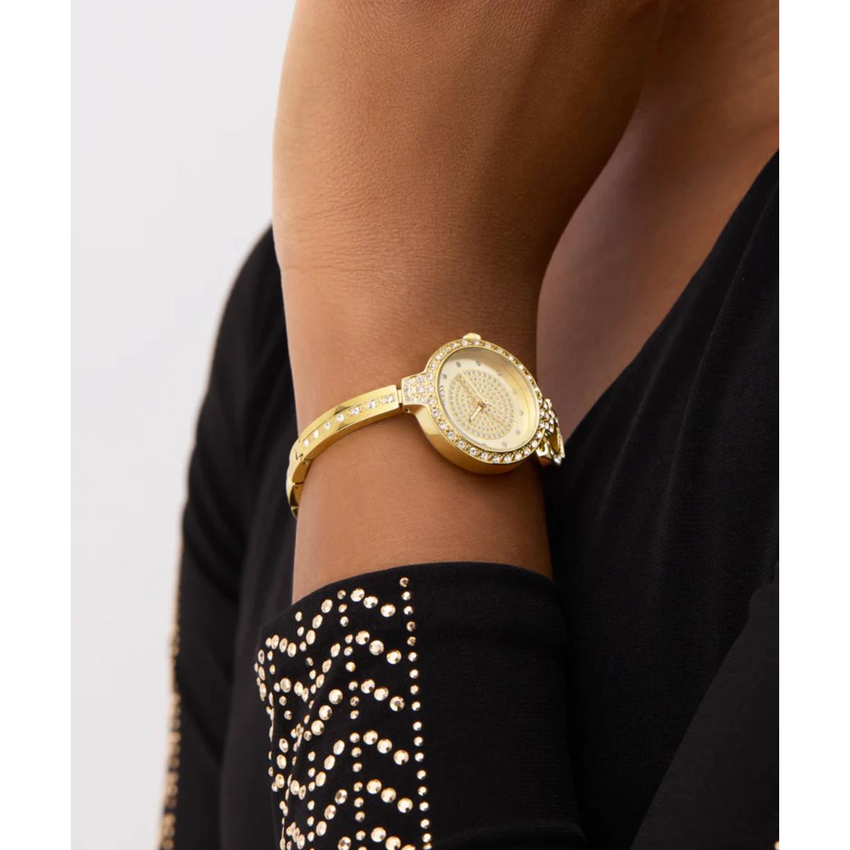 Gold wristwatch on a person's arm with a black outfit