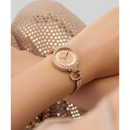 Rose gold watch with diamond accents on a wrist against a neutral background
