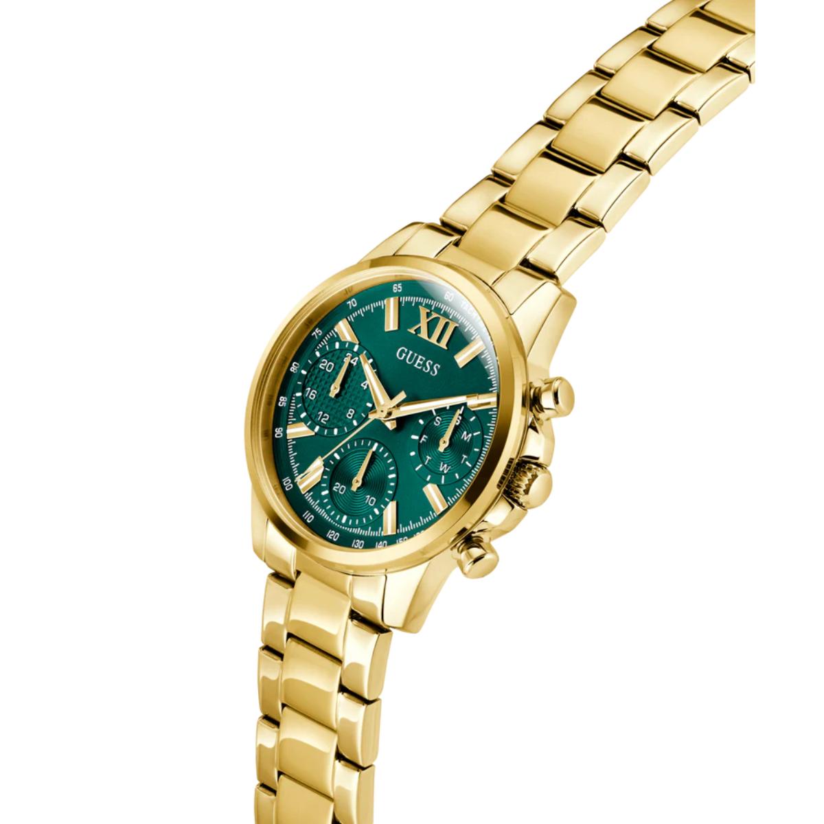 Gold-tone women's analog watch with a green dial and matching green subdials, featuring gold-tone hands, Roman numeral XII, and a gold-tone link bracelet. The brand GUESS is visible on the dial.