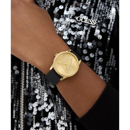 Gold watch on a wrist with a sequined background