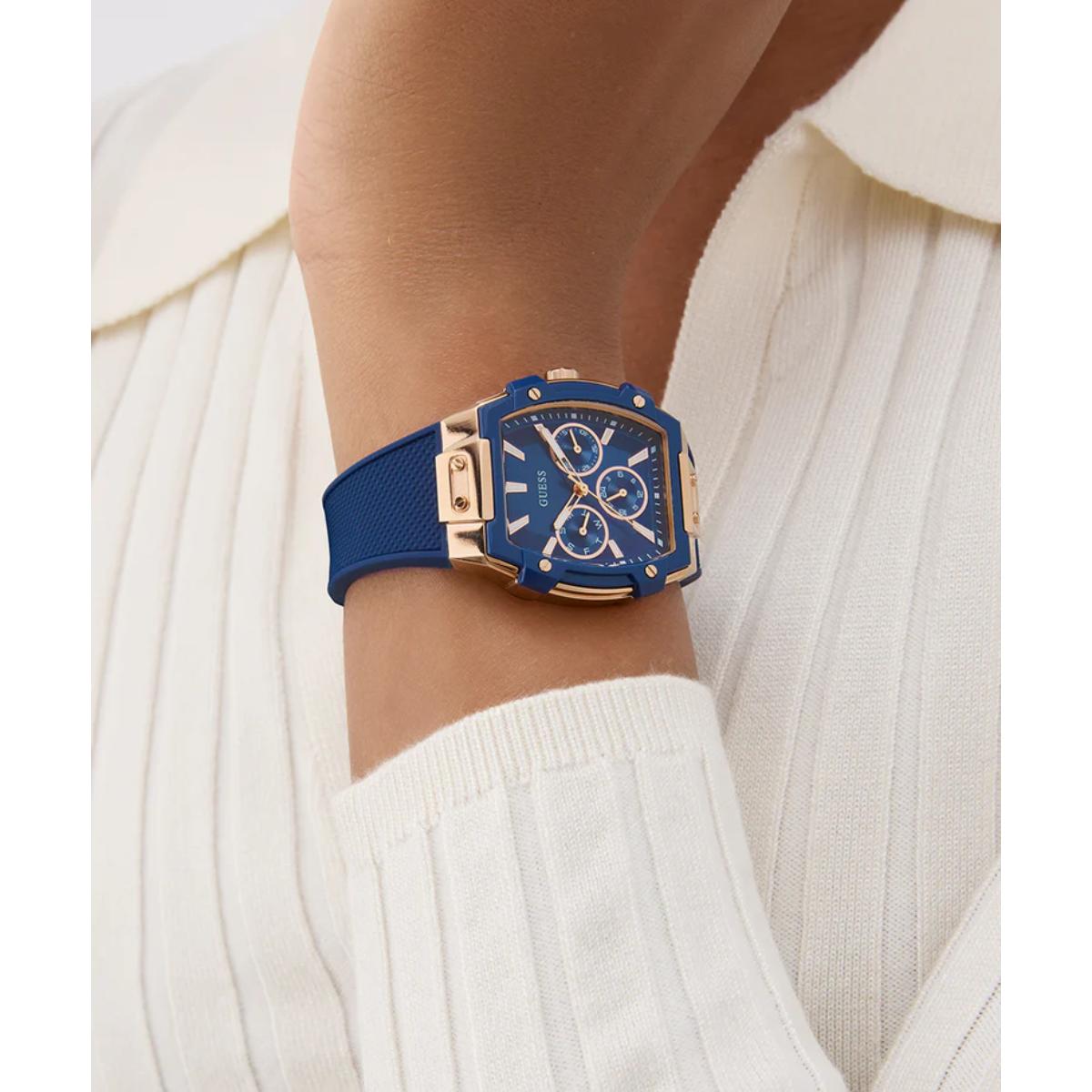 Blue watch with gold accents on a wrist against a white background
