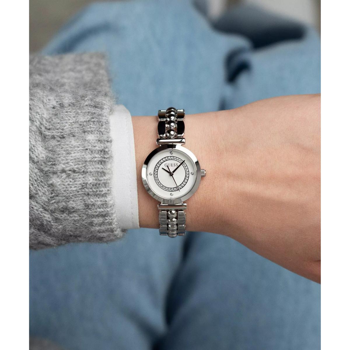 Silver watch on a wrist with a blurred background