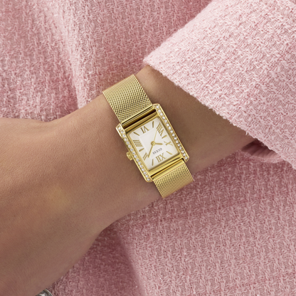 Gold watch on a wrist with a pink textured background