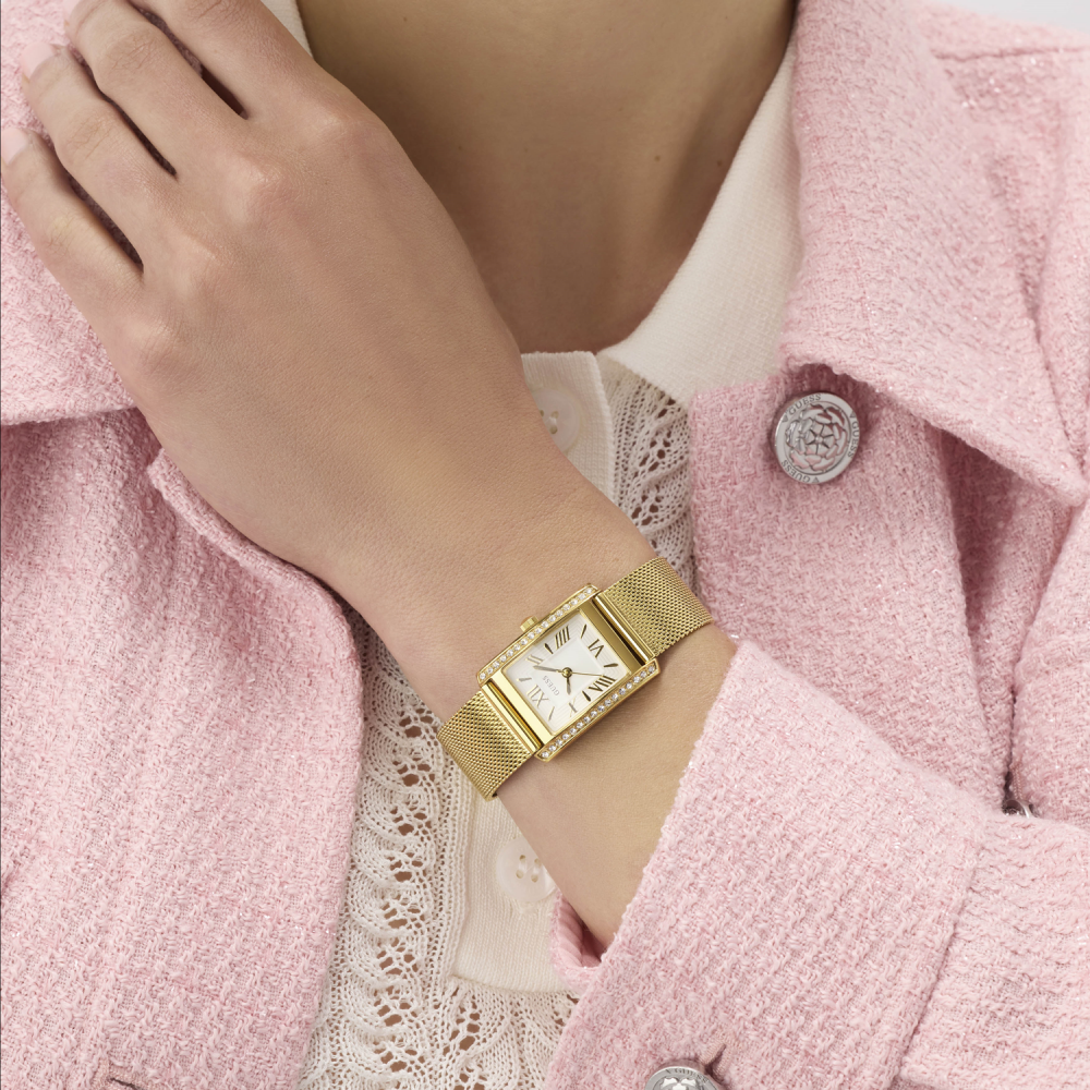 Gold watch on a wrist with a pink coat
