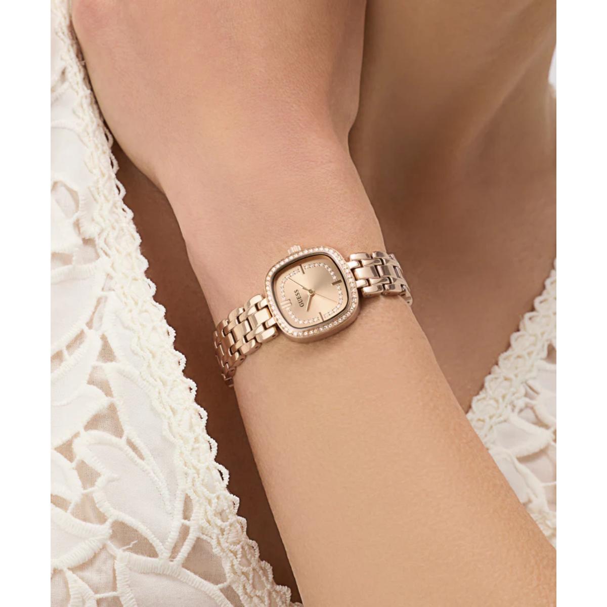 Rose gold watch on a wrist with a white lace garment