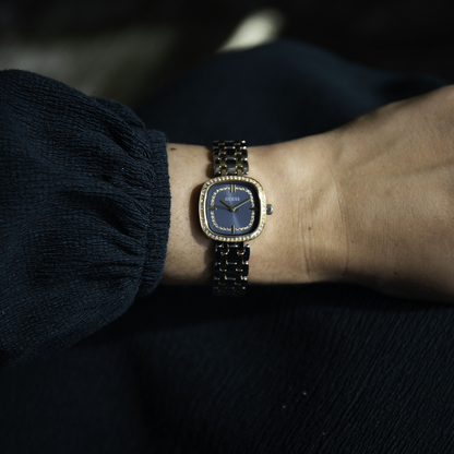Watch on a wrist with a dark background