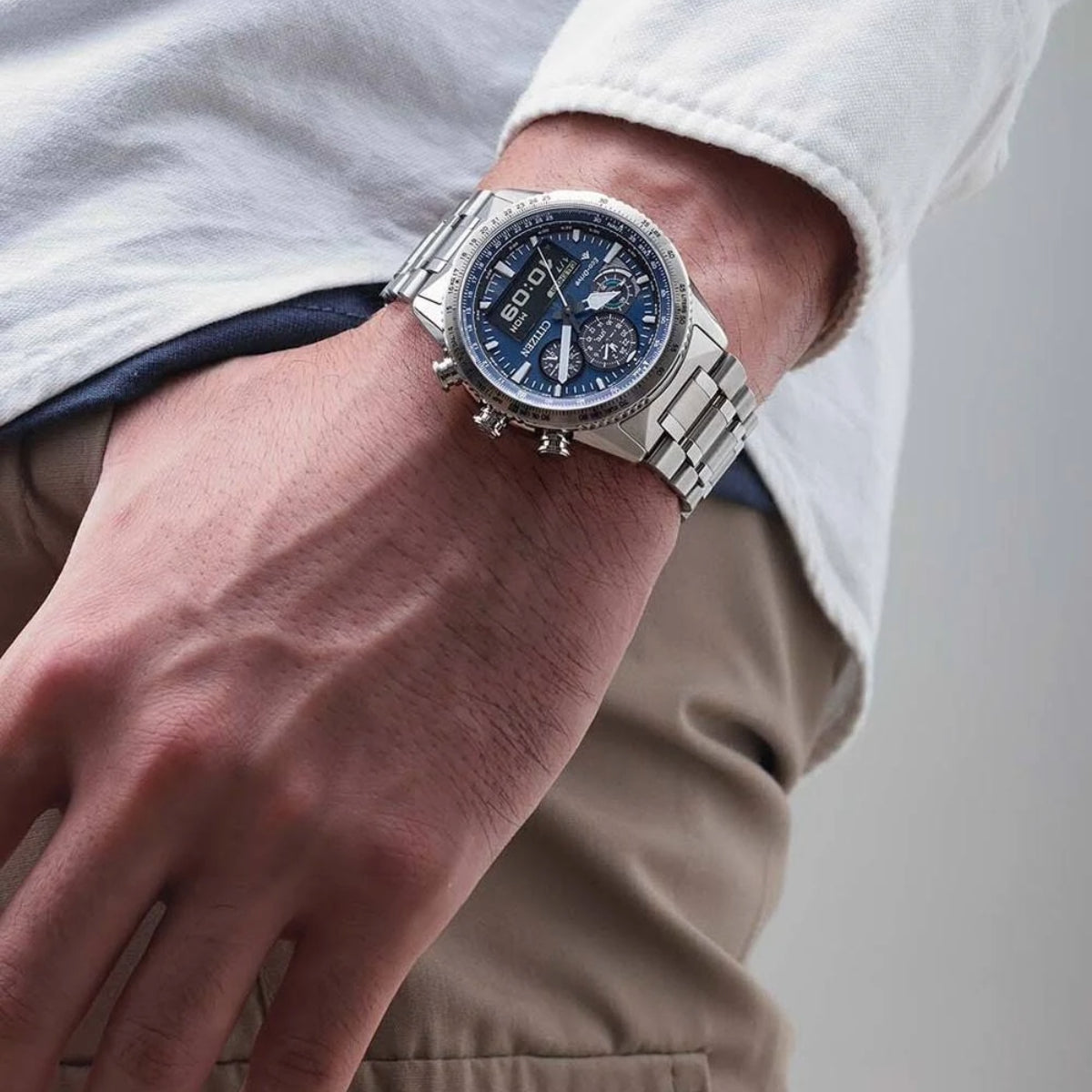 Close-up of a person's wrist wearing a silver watch with a blue face.