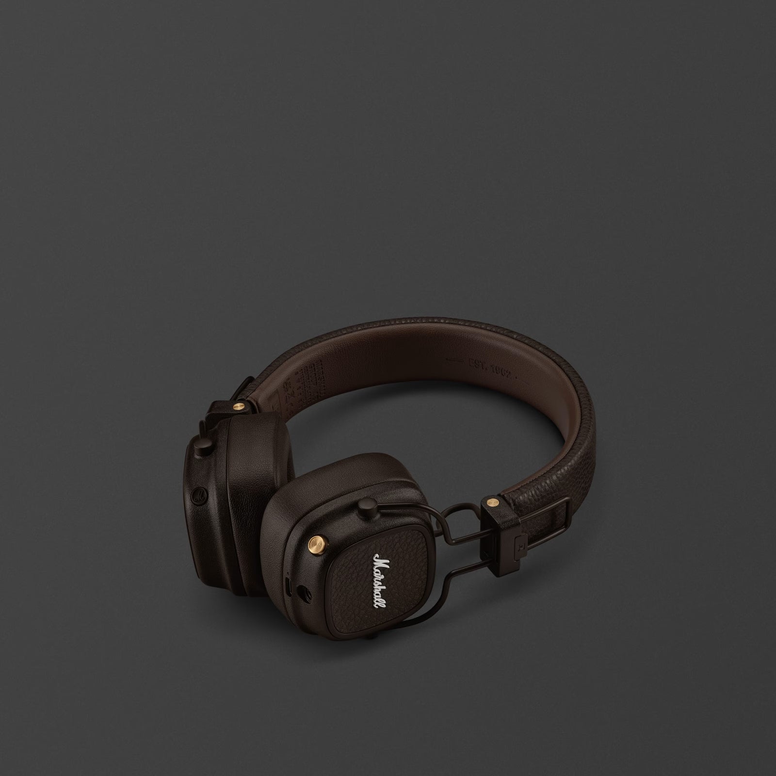 Brown headphones with Marshall logo on a dark gray background