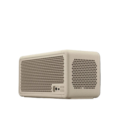Beige rectangular speaker with perforated design on a dark background