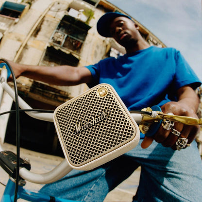 Person holding a Marshall speaker with a rustic background
