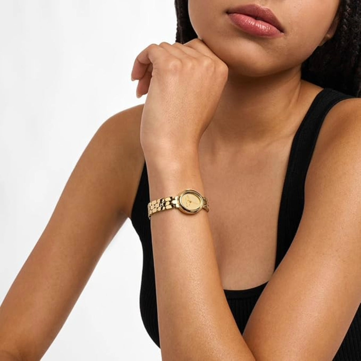 Woman wearing a gold watch on a white background