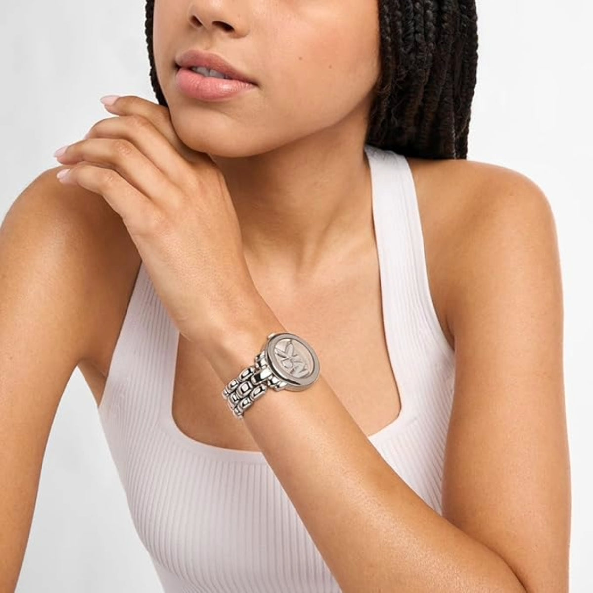 Woman wearing a silver bracelet on a plain background