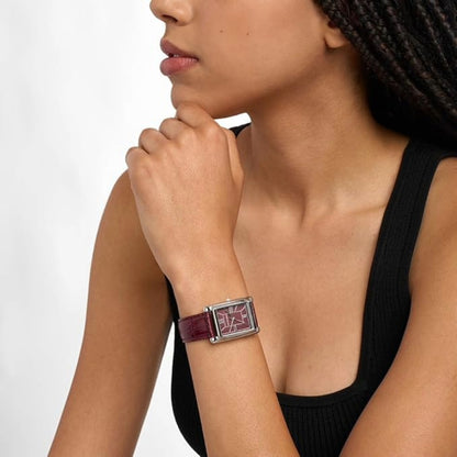 Woman wearing a bracelet on a plain background