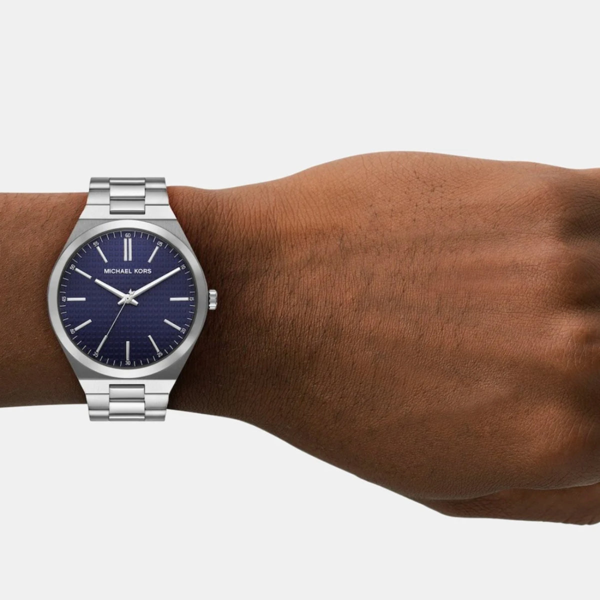 Silver watch with a blue dial on a wrist against a white background