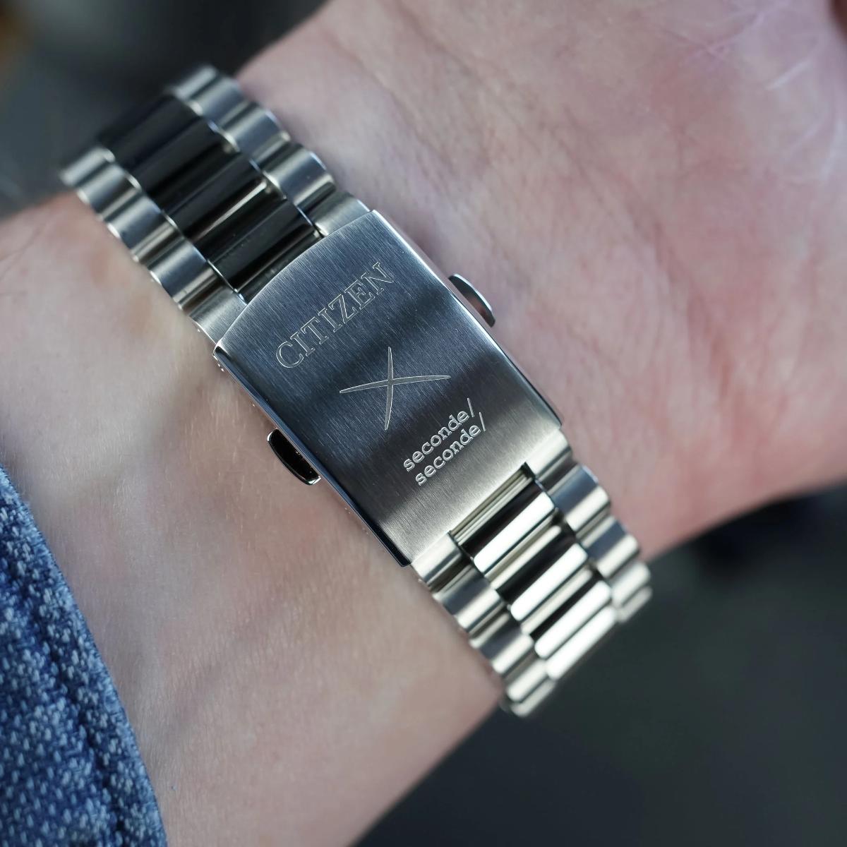 Silver Citizen watch on a wrist with a blurred background