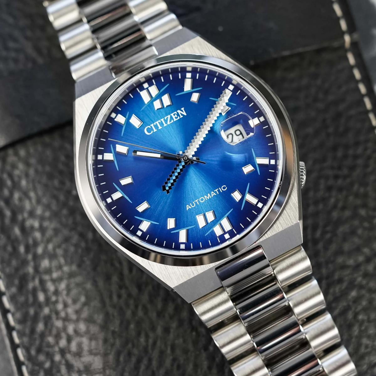 Silver Citizen watch with a blue face on a textured black background