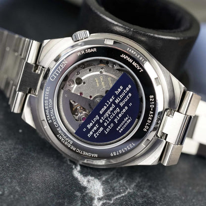 Close-up of a Citizen watch with visible mechanical components and text on a dark background