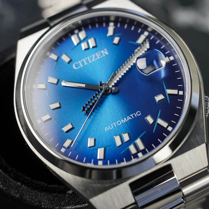 Citizen watch with blue dial and silver case on a blurred background