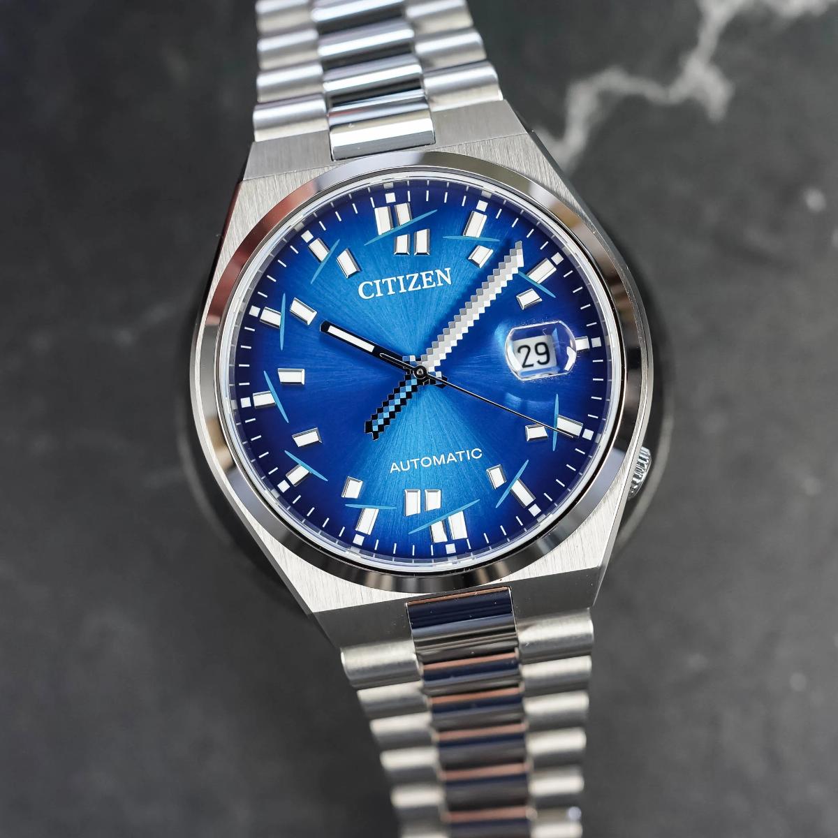 Silver Citizen watch with a blue face on a dark marble background