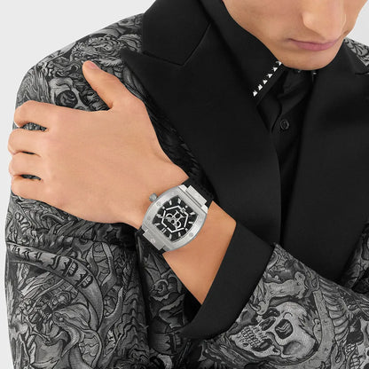Person wearing a silver watch with a unique face, dressed in a black shirt with a patterned design.